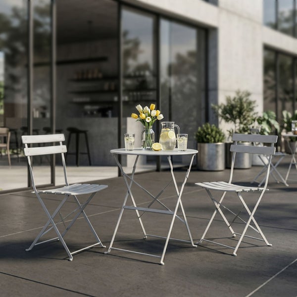 Klappbares Bistrotisch-Set bestehend aus zwei Klappstühlen und einem runden Metalltisch auf einer modern gestalteten, geräumigen Terrasse.