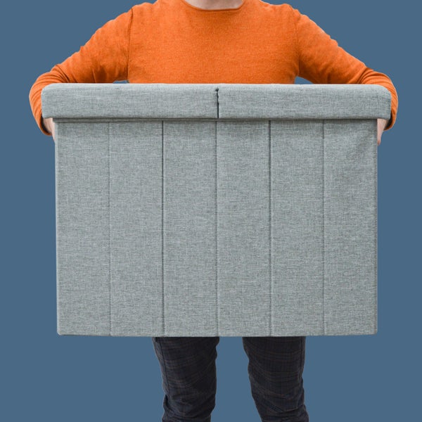 Große graue Aufbewahrungsbox aus Stoff mit Deckel, gehalten von einer Person.