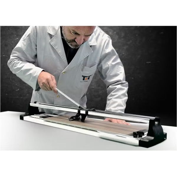 Manueller Fliesenschneider im Einsatz beim präzisen Schneiden einer Fliese in Holzoptik.