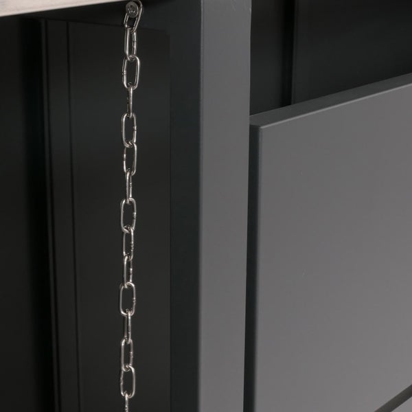 Detailansicht einer Metallkette vor einer grauen Holzkonstruktion