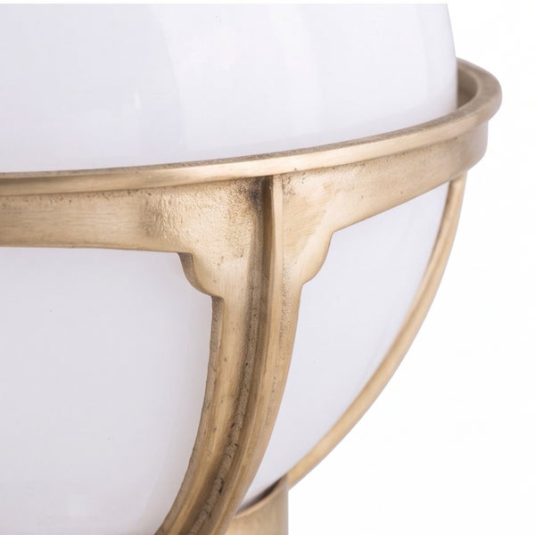 Nahaufnahme einer Leuchte mit weißem kugelförmigem Diffusor und einem Metallgestell in Altmessing-Optik.