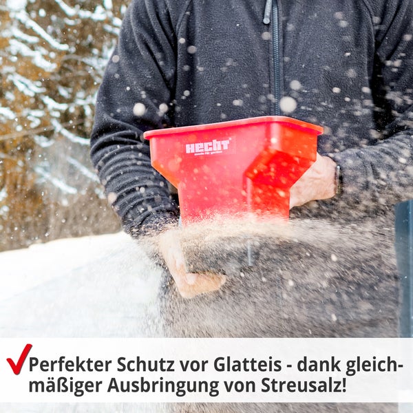 Eine Person verwendet einen Streuwagen der Marke Hecht, um Streusalz auszubringen