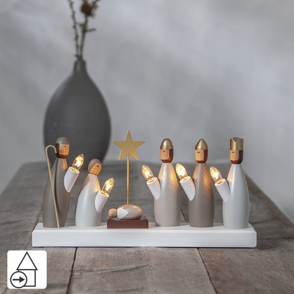 Weihnachtskrippe mit Figuren und Beleuchtung auf einem Holztisch