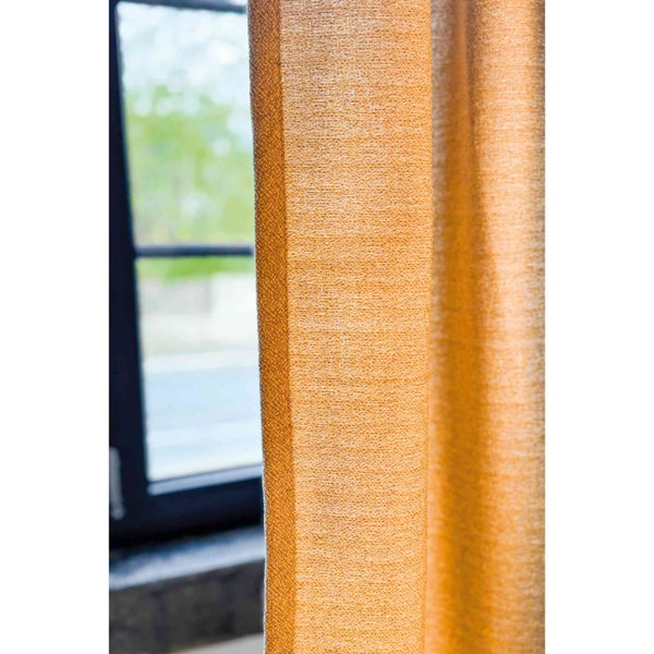 Nahaufnahme eines orangefarbenen Vorhangs neben einem Fenster