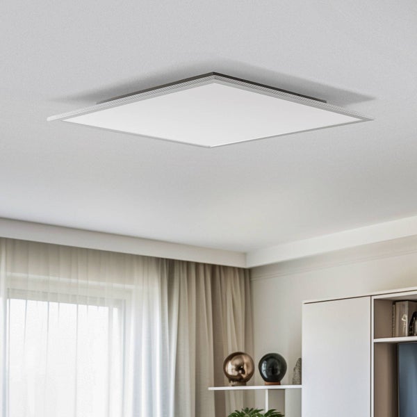 Modernes quadratisches LED-Deckenpanel in einem hellen, aufgeräumten Zimmer mit Schrank und Vorhängen.