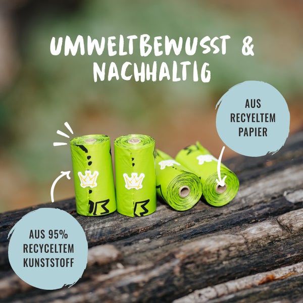 Mehrere grüne Hundekotbeutelrollen aus recyceltem Papier und recyceltem Kunststoff auf einem Holzuntergrund
