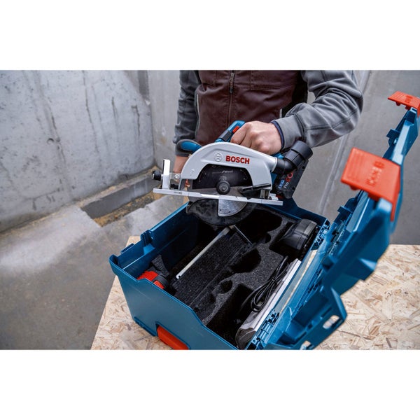Person legt eine Bosch Kreissäge in einen Werkzeugkoffer
