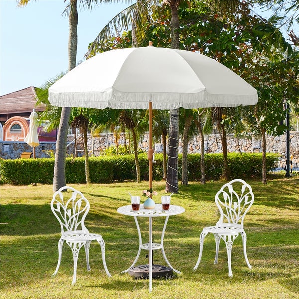 Gartenszene mit weißem Sonnenschirm, Tisch und Stühlen auf Rasen