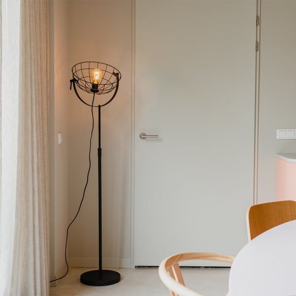 Stehleuchte mit Lampenschirm in Käfigoptik im Wohnraum