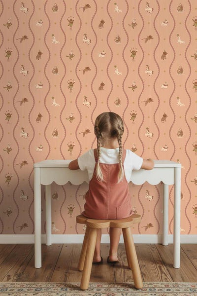 Kindertapete mit Zirkusmotiven zwischen vertikalen Wellenlinien im Kinderzimmer mit Schreibtisch und Holzschemel.