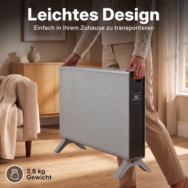 Person trägt einen leichten, mobilen Elektrokonvektor mit Digitalanzeige im Wohnzimmer.