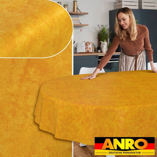 Gelbe ovale Wachstuch-Tischdecke mit marmorierter Struktur auf einem Tisch in einer hellen Küche und Detailansicht des Materials, ANRO Logo.