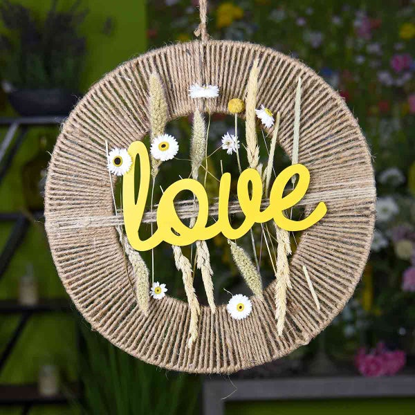 Dekorativer Türkranz mit dem Wort Liebe, Trockenblumen und Jute