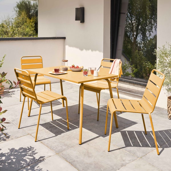 Moderne gelbe Garten-Essgruppe aus Metall mit einem rechteckigen Tisch und vier Stühlen auf einer hellen Steinterrasse.