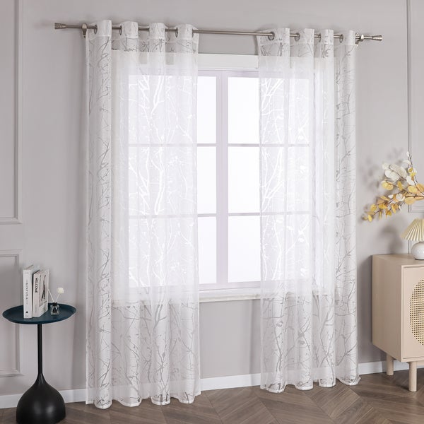 Fenster mit weißen Vorhängen und Baumdesign in einem hellen, geräumigen Raum.