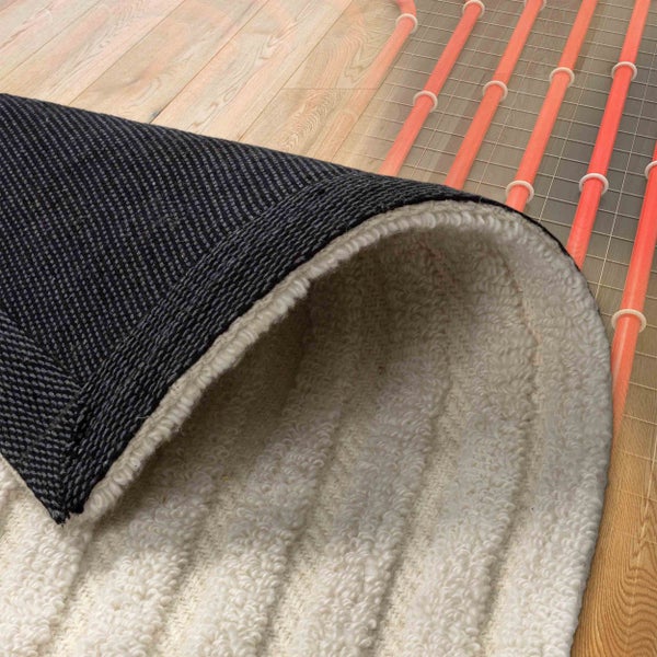 Teppich mit strukturierter Oberseite und weicher Unterseite auf Holzboden mit sichtbarer Fußbodenheizung.