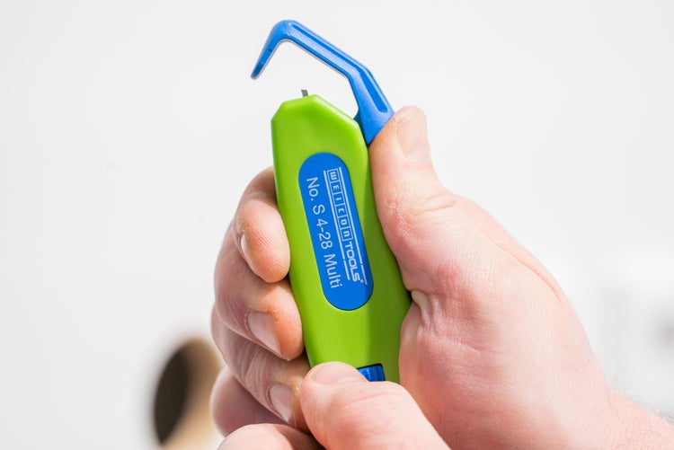 Abisolierwerkzeug in der Hand