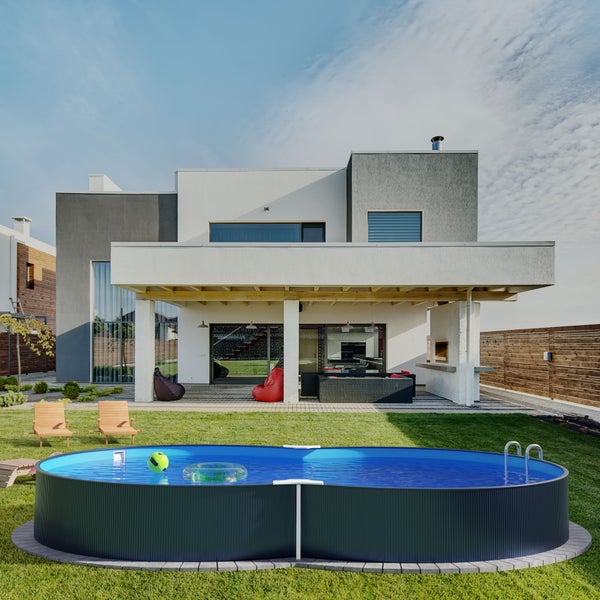 Gartenansicht mit Pool, Liegestühlen und modernem Haus