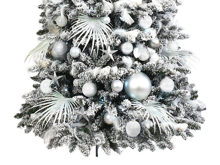 Geschmückter künstlicher Weihnachtsbaum mit Kunstschnee, Kugeln, Sternen, Federn und dekorativen Pflanzen in winterlichem Design.