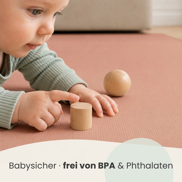 Ein Kleinkind spielt auf einer weichen Bodenmatte mit Holzspielzeug, das Produkt ist babysicher und frei von Bisphenol A und Phthalaten.