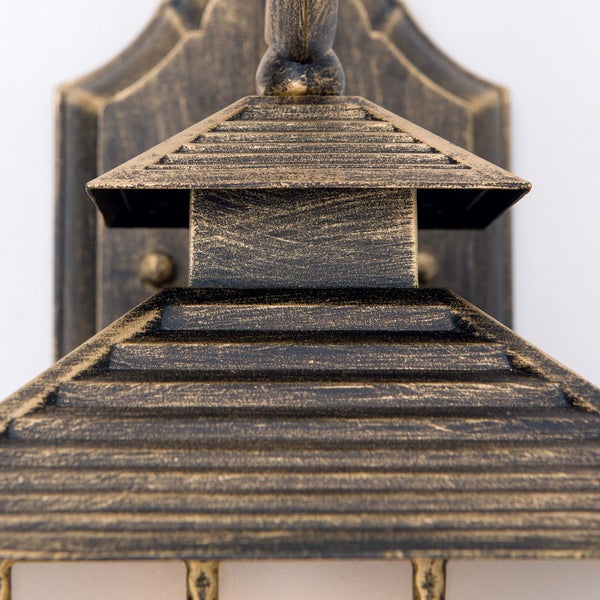 Detailansicht einer Außenwandleuchte aus Metall mit antikem Finish und geripptem, pyramidenförmigem Dach.