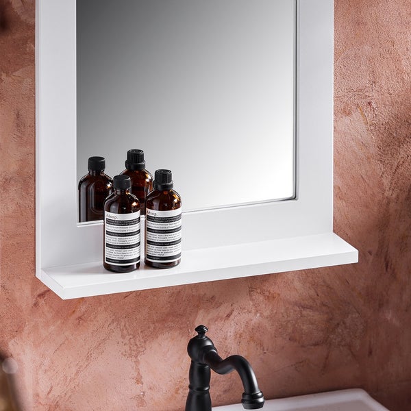 Detailansicht eines Badezimmerspiegels mit Ablage und Kosmetikprodukten