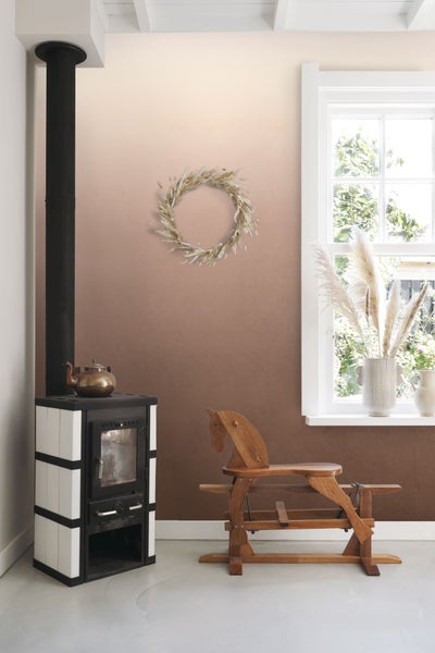 Wohnraum mit Kaminofen, Holzpferd und Fenster