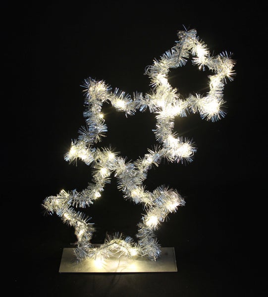 Dekorative Sternleuchte mit silberfarbenem Lametta und warmweißen Lichtern auf einem Sockel