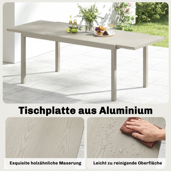 Sechs Personen sitzen an einer Esstischgruppe aus Metall unter einer Holzpergola auf einer Terrasse mit Gartenblick.