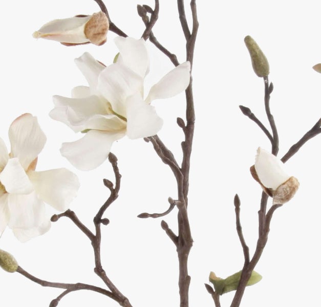 Künstlicher Magnolienzweig mit weißer Blüte und grünen Blättern.