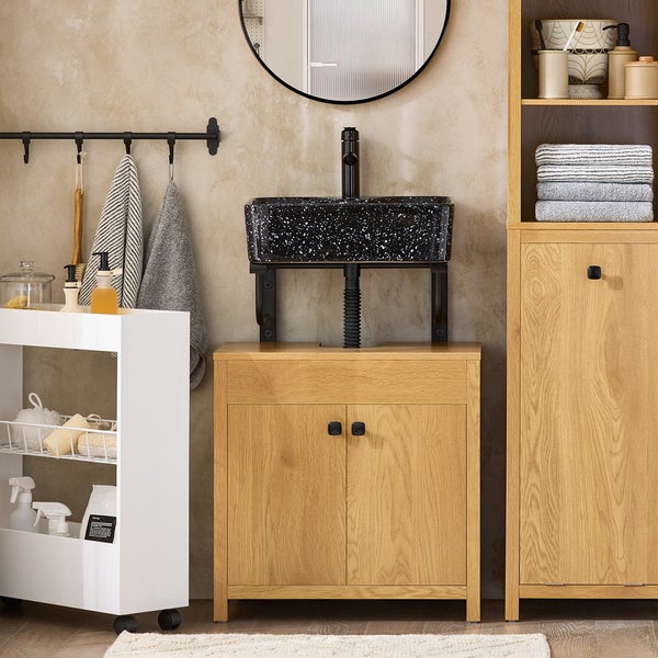 Badezimmer mit Waschtischunterschrank, Aufsatzwaschbecken, Spiegel und Handtuchhalter für eine organisierte Atmosphäre.