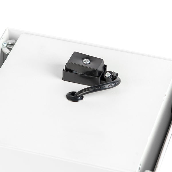 Detailansicht einer schwarzen Kabeldurchführung und Anschlussdose auf einer weißen Metalloberfläche.