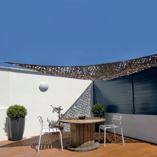 Terrasse mit Sonnensegel in Tarnnetz-Optik über einem runden Holztisch und zwei weißen Stühlen.