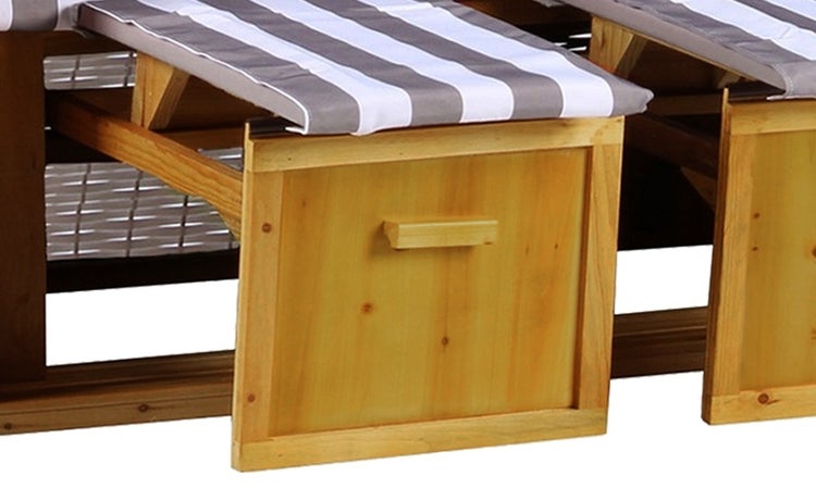 Detailansicht eines Strandkorbs mit Bullauge und gestreiftem Innenfutter.