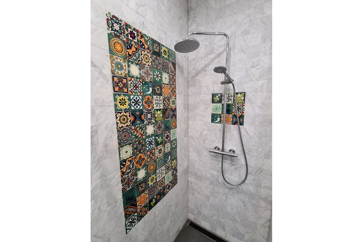 Küchenszene mit bunten Fliesen, Dunstabzugshaube und Küchenutensilien.