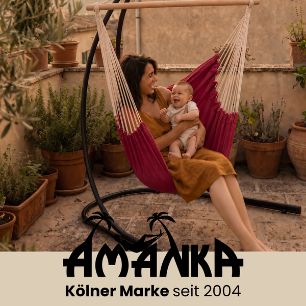 Mutter mit Baby in einem freistehenden Hängesessel auf einer Terrasse mit zahlreichen Pflanzen im Topf Amanka Logo Kölner Marke seit 2004