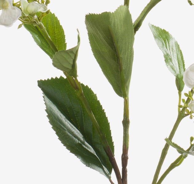 Künstlicher Zweig mit weißen Blüten und grünen Blättern.