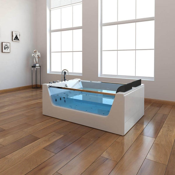 Moderne Whirlpool Badewanne mit Glasfront und integrierten Armaturen in einem hellen, großzügigen Badezimmer mit Holzboden.