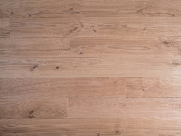 Holz-Bodenbelag in Dielen-Optik mit sichtbarer Maserung und Astlöchern.