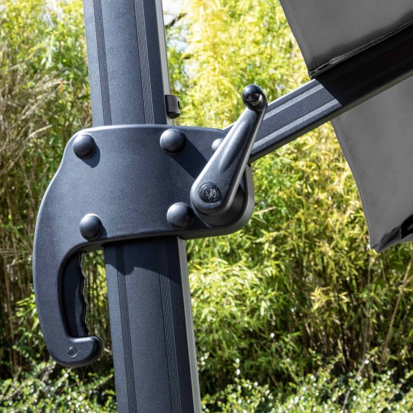 Kurbelmechanismus eines Sonnenschirms mit Handgriff an einem dunklen Metallmast.