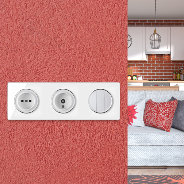 Eine dreifache Kombination aus Steckdose, Antennensteckdose und Lichtschalter in weißem Design auf einer strukturierten roten Wand.