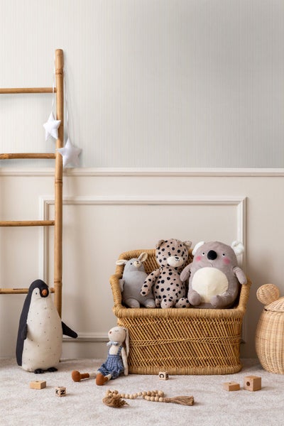 Helles Kinderzimmer mit fein gestreifter Tapete und dekorativen Wandleisten, ausgestattet mit einer Holzleiter und Korbobjekten.