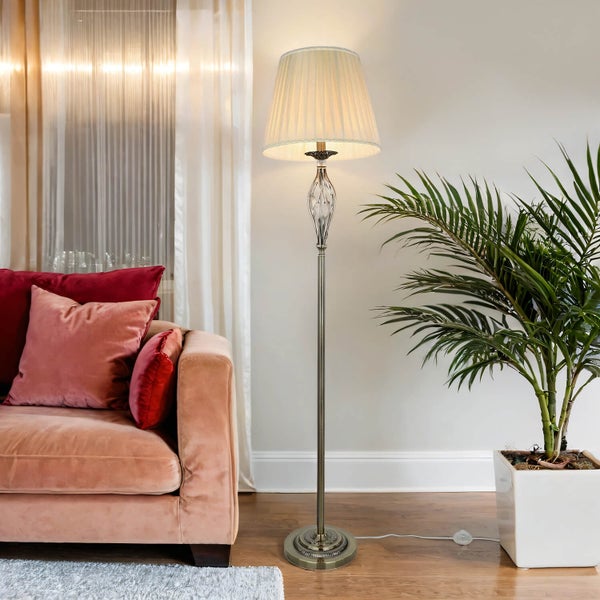 Wohnzimmer-Szene mit Stehlampe, Sofa, Zimmerpflanze und Vorhängen für eine helle Atmosphäre