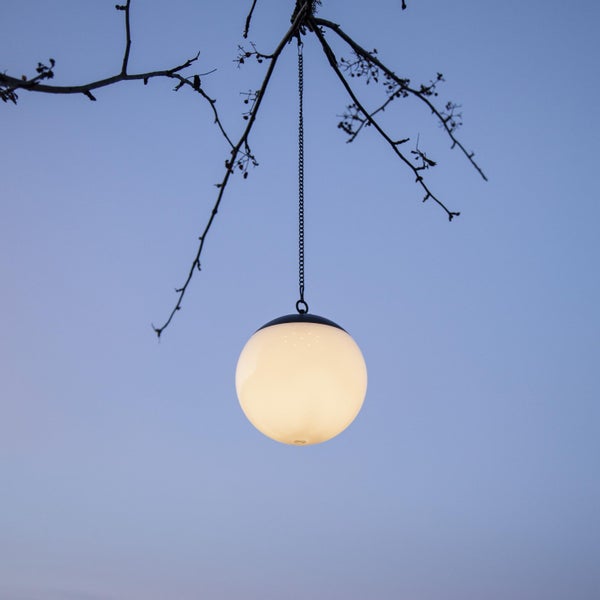 Kugelförmige Hängeleuchte hängt an einem Ast