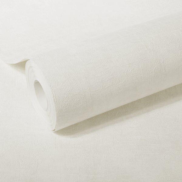 Szene mit beiger Vliestapete an der Wand und Gegenständen auf einem Tisch