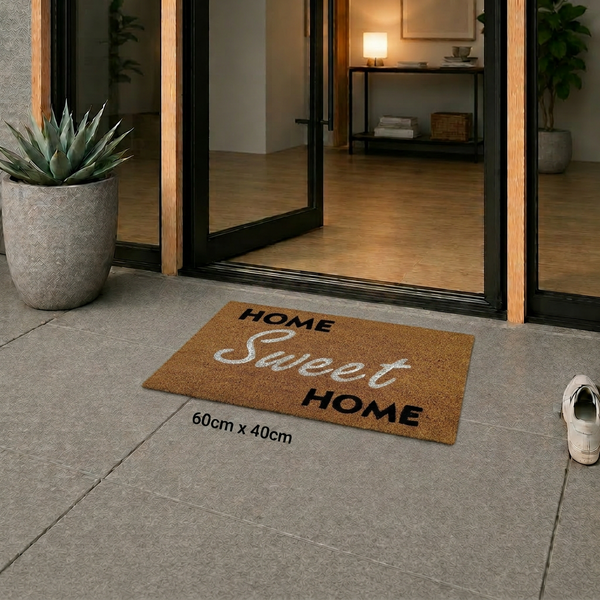 Kokos-Fußmatte mit Schriftzug Home Sweet Home vor einer Glastür auf Fliesenboden, Maße 60 mal 40 Zentimeter.