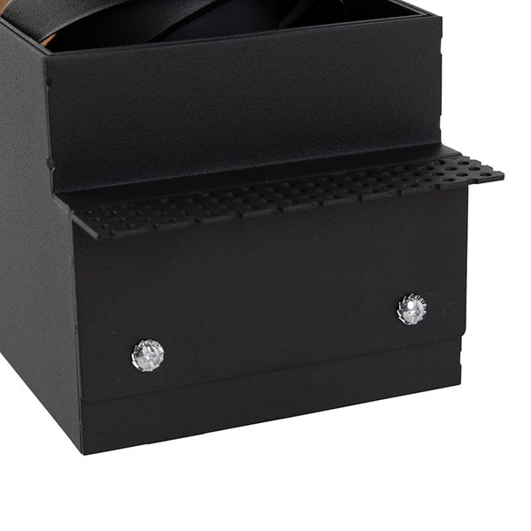 Detailansicht einer schwarzen Wandleuchte aus Metall mit einem perforierten Element und zwei silbernen Schrauben.