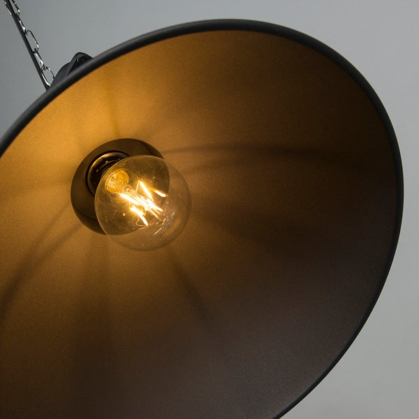 Innenansicht eines runden schwarzen Lampenschirms aus Metall mit einem leuchtenden LED-Leuchtmittel und einer Kette.