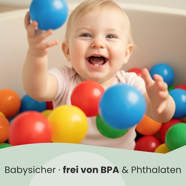 Lachendes Baby spielt in einem Bällebad mit Kunststoffbällen. Das Produkt ist babysicher und frei von Bisphenol A und Phthalaten.