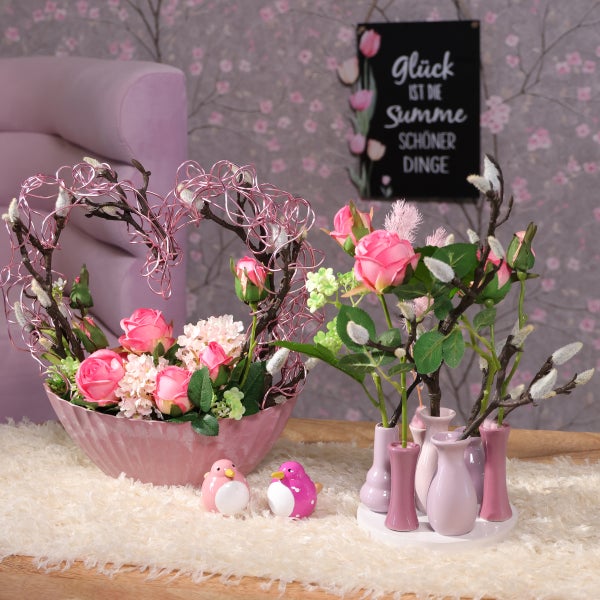 Dekorative Tischszene mit Blumenarrangement, Vasen und Zierfiguren